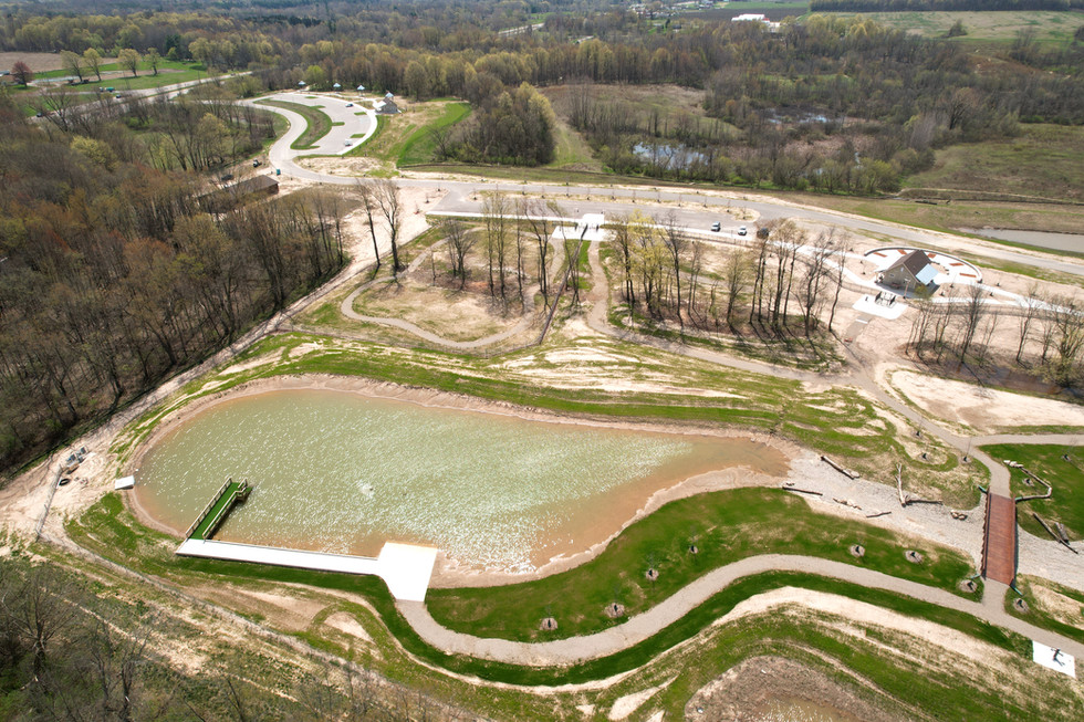 Aerial drone view of Wahlfield Park dog park construction in West Michigan showing pond, trails, and site development progress