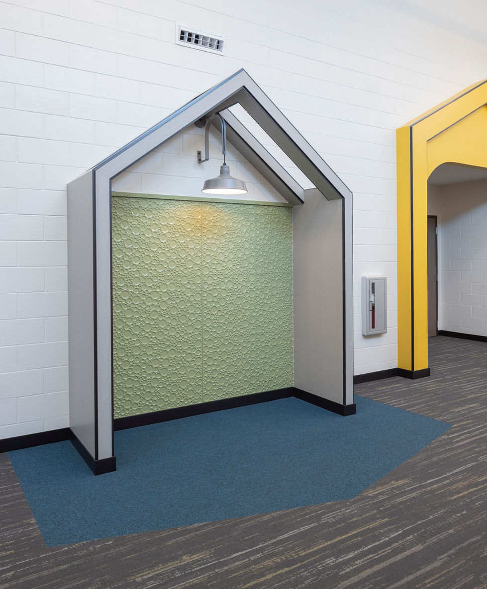 Small, house-shaped alcove with green wall and light.