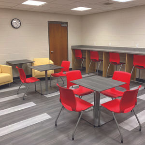 Room with red chairs and tables, yellow sofas.