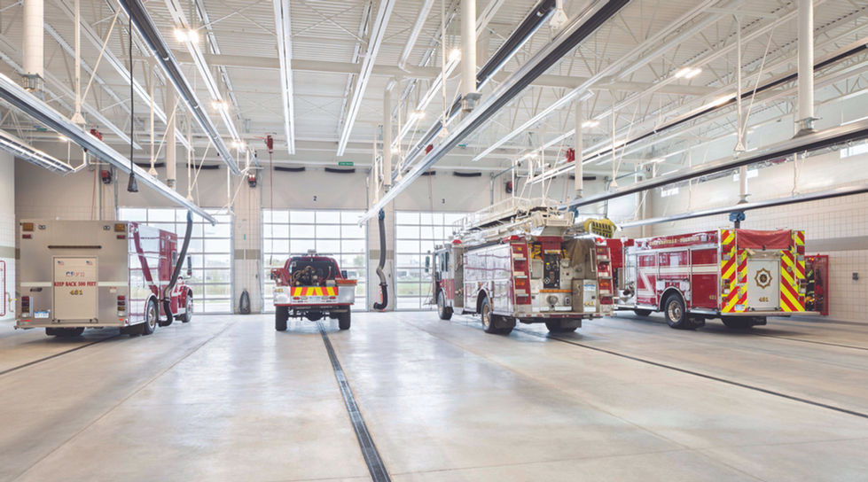 Fire trucks parked inside a spacious fire station.