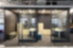 Modern commercial office interior with glass walls and exposed ceiling, highlighting integrated planning and collaboration in construction