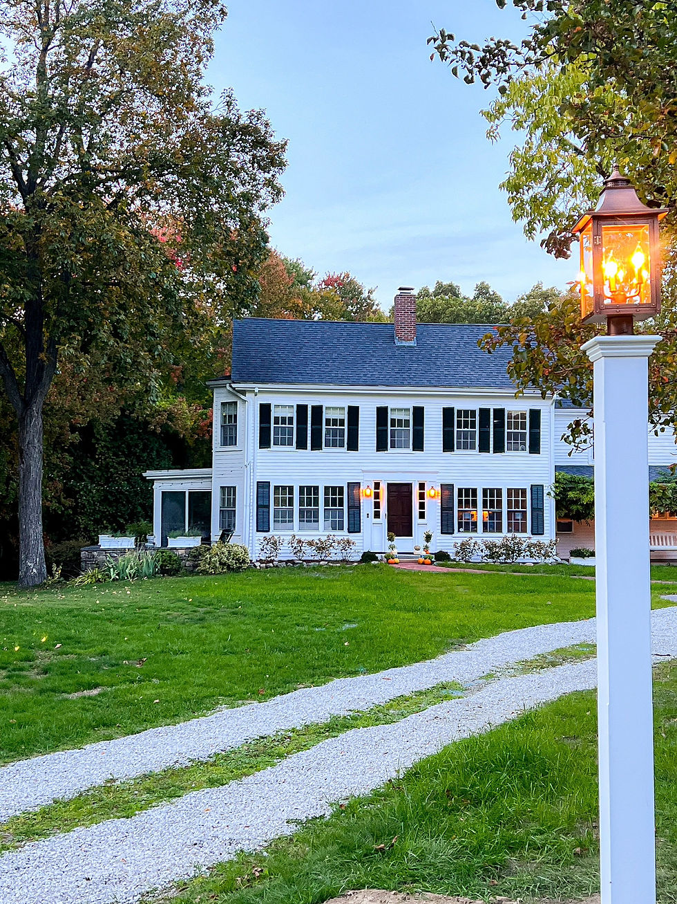 Massachusetts farmhouse in fall with lots of land around it and shedding trees