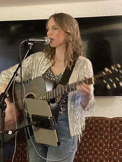 Rachel Makena performing live acoustic music in a pub setting