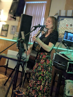 Rachel Makena singing live with her acoustic guitar