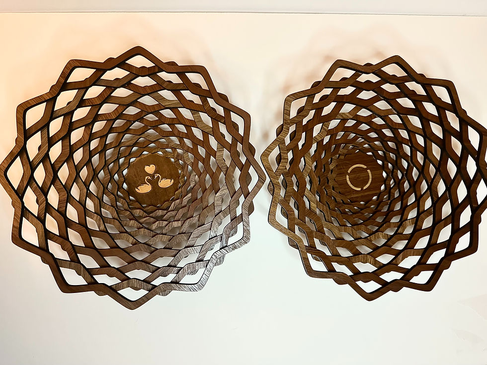 Two ornate spiraling wooden bowls, one with a flower design
