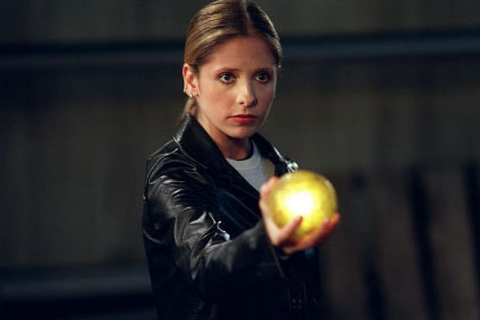 Buffy in leather and a ponytail, holding out a mysteriously glowing orb like it’s just another Tuesday on the Hellmouth.