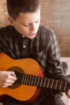 7 year old st alabns studen playing guitar in a St Albans lesson
