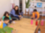 Teacher guiding children through a life-size self-portrait art project