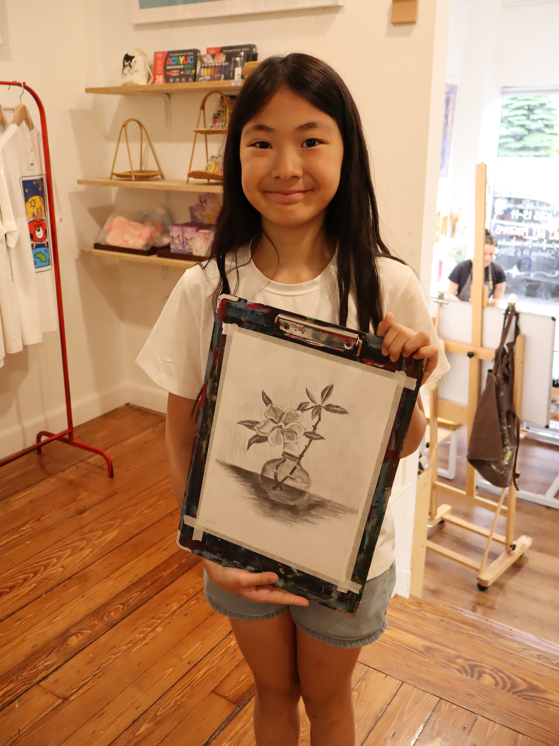 Student holding drawing artwork at TONGWOOD Art Center in Brookline