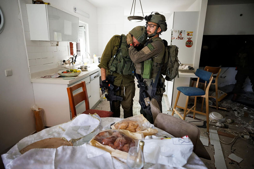 Soldiers weep in the wreckage of a home at Kibbutz Kfar Aza