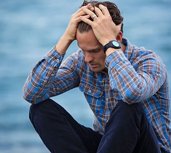 Person with hands on head with a look of stress on their face