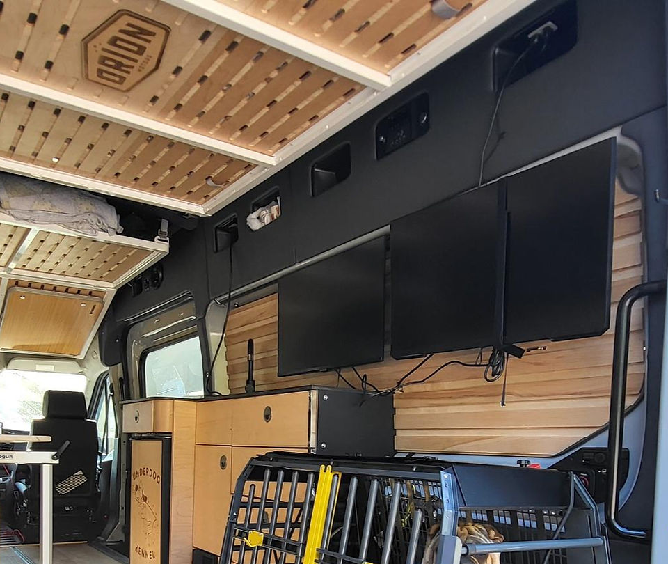 two large monitors on the inside wall of the van