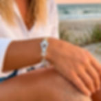 Virgin Islands VI hook bracelet in hammered sterling silver with 14k gold wire wrap display on a model wrist.