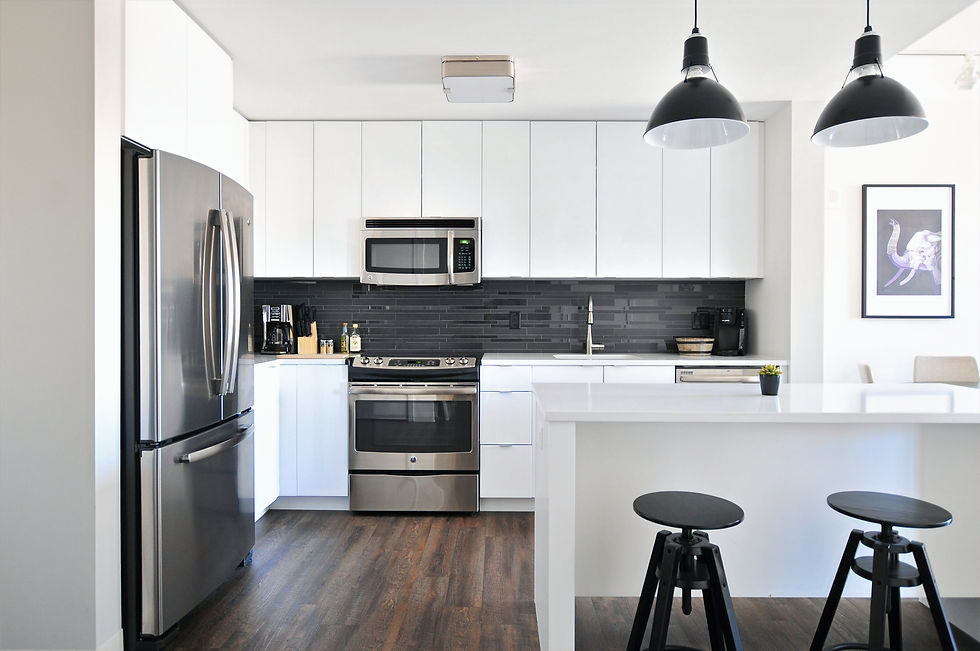 Modern kitchen with white cabinets, stainless steel appliances, and a black tile backsplash