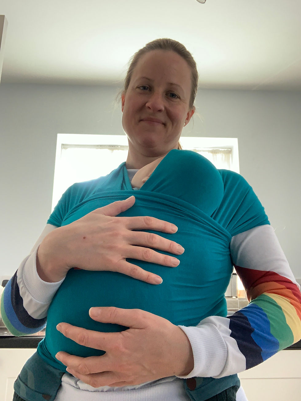 Doula carrying baby in sling