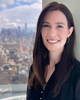 Portrait photo of Lena at a window overlooking a metropolitan area.