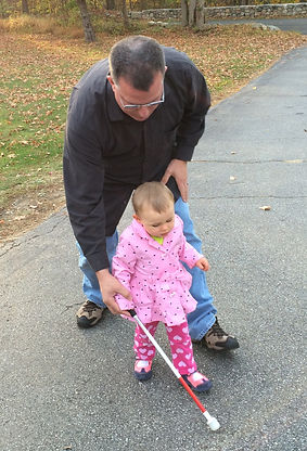 Toddler receiving cane instruction from COMS John Kelly.