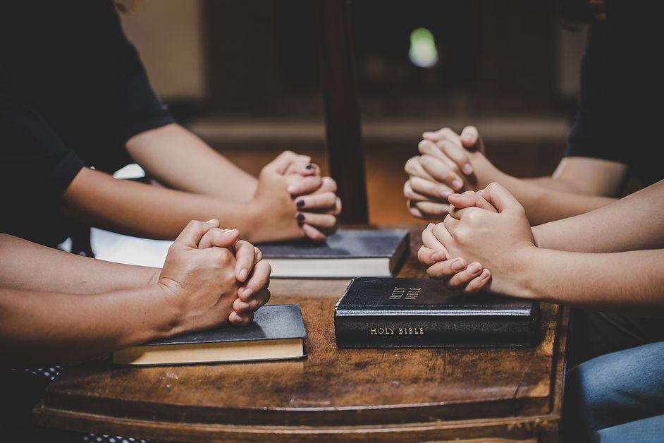 Christian family worship God in home with holy bible on wooden table.jpg