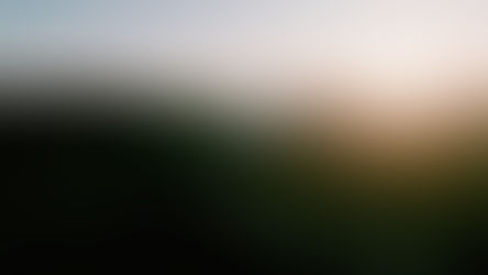 Sunrise over lush green mountains and winding roads, with misty valleys and a serene sky, creating a peaceful and tranquil scene.