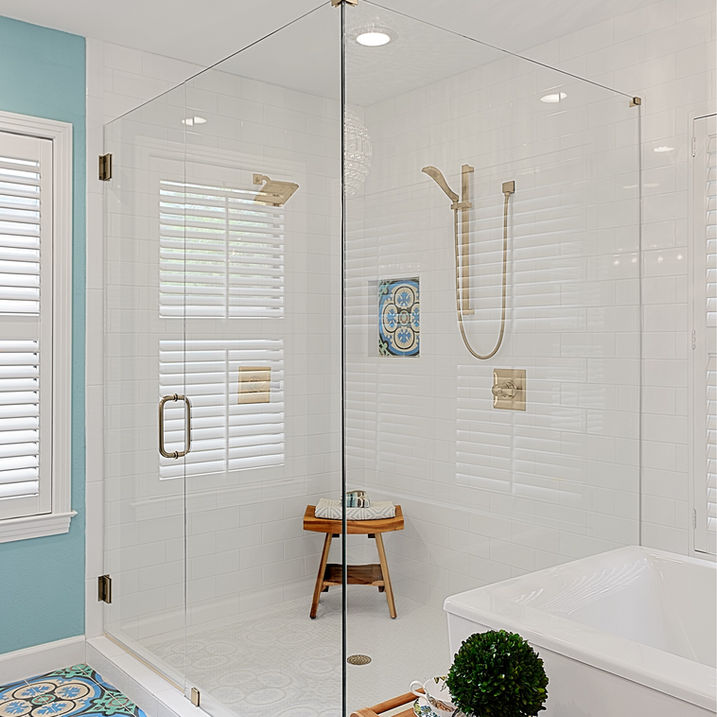Fun turquoise primary bath, with Mexican encaustic patterned tile, white subway tiled walls, heavy glass, corner shower, large beveled glass mirrors, quartz countertops, crystal chandelier, blue walls, pineapple lighting sconces, dark shaker style cabinetry, French champagne plumbing fixtures, soaker tub.