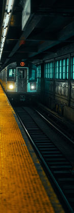 Subway train approaching a dark platform at night