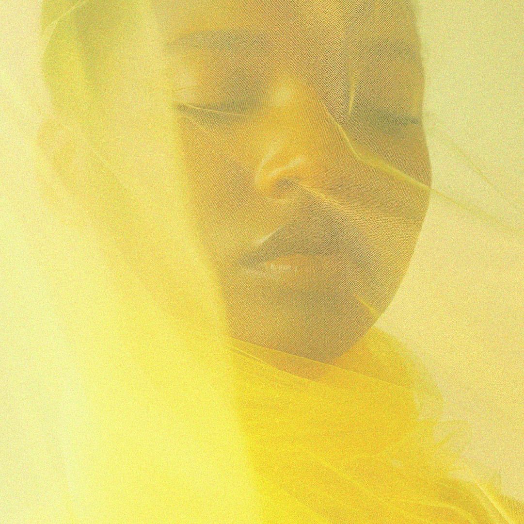 dark skinned woman covered by a semi transparent vibrant yellow cloth