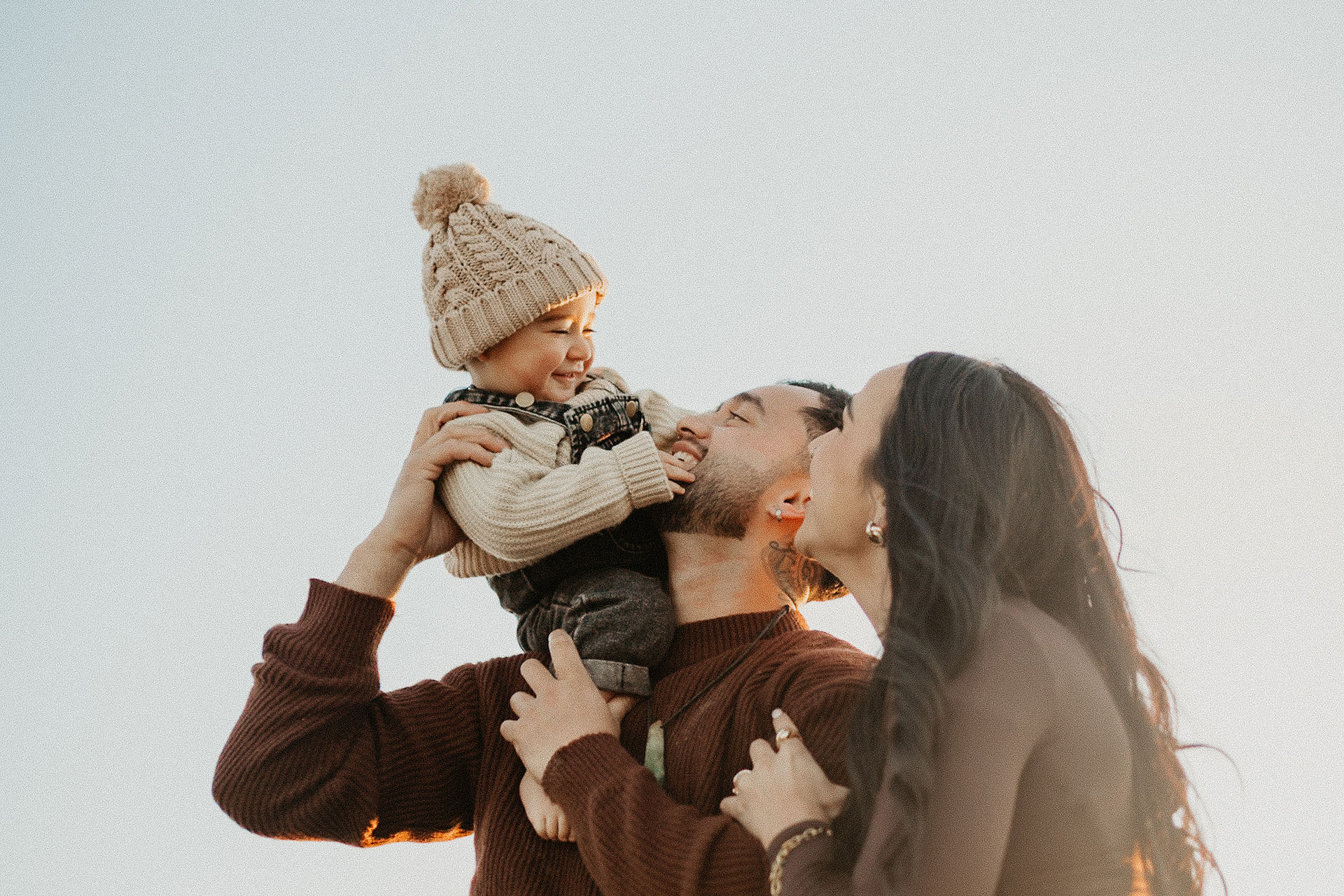 Parents playfully interacting with their toddler at Thornton Beach NZ
