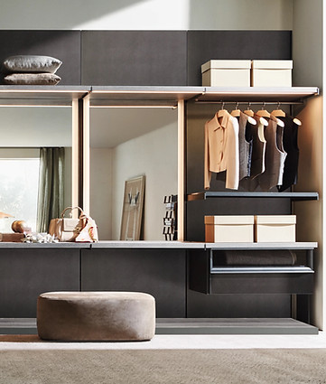 Modern dressing room with illuminated open wardrobes, hanging rails, mirrors, and integrated drawers.