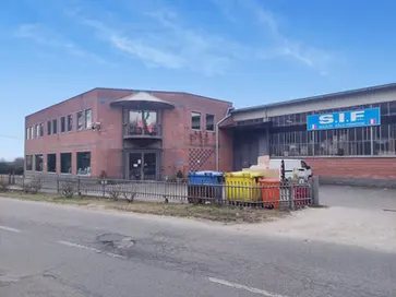 Vista esterna della sede di S.I.F. S.r.l. con parcheggio e bidoni colorati.
