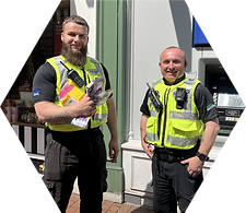 Two SWL Security employees working for the Reading Business Improvement District (BID), standing outside a cash machine after retrieving stolen goods. Equipped with high-visibility vests and communication devices, they ensure safety and provide effective retail support in Reading's busy shopping district.