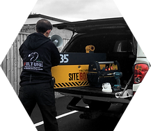 Man putting Vulture CCTV Site Box into back of white truck with makita and stanley tools and hikvision surveillance camera.