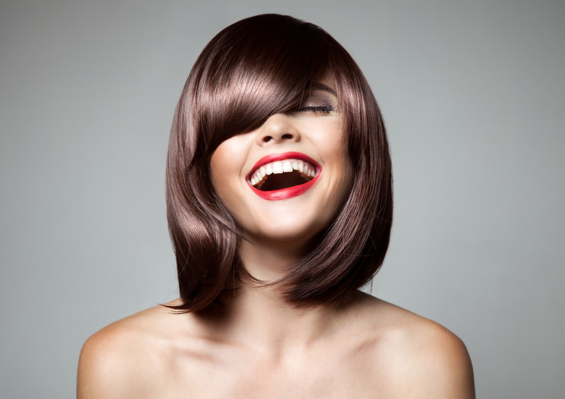 A smiling woman with stylish, short, brunette hair