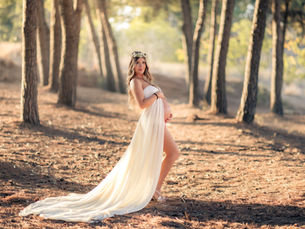 Mujer embarazada en vestido blanco en la naturaleza