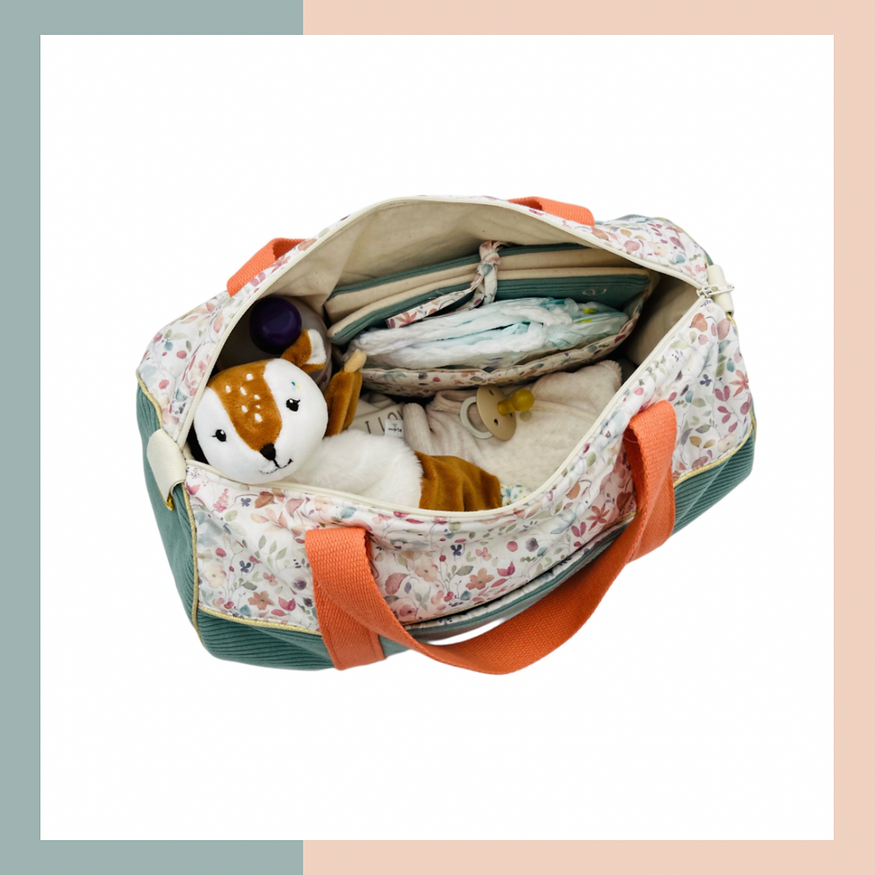 Sac à langer gris avec fleur, sangles orange, ouvert avec affaires hygiène bébé