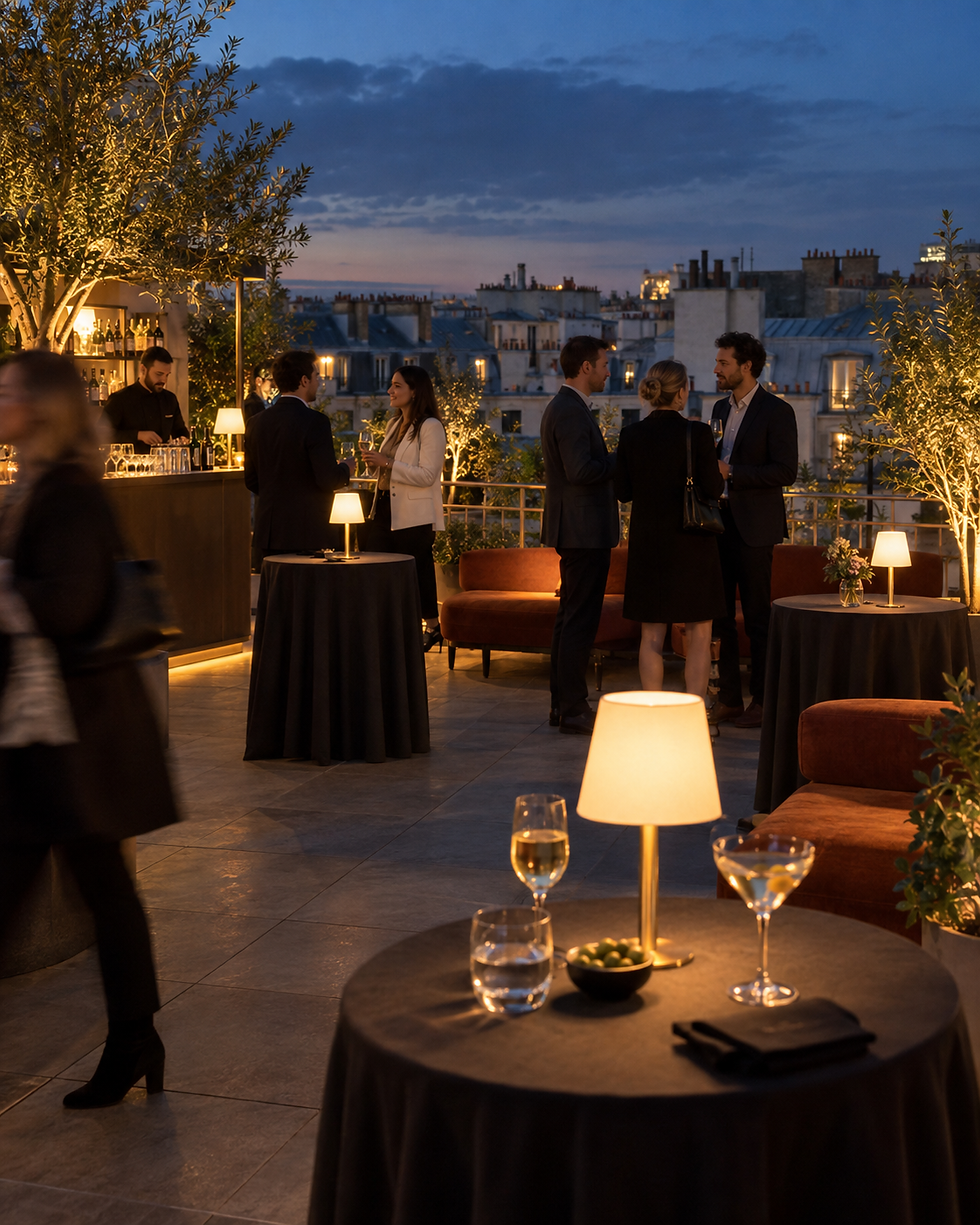 Soirée cocktail sur un rooftop parisien au crépuscule.