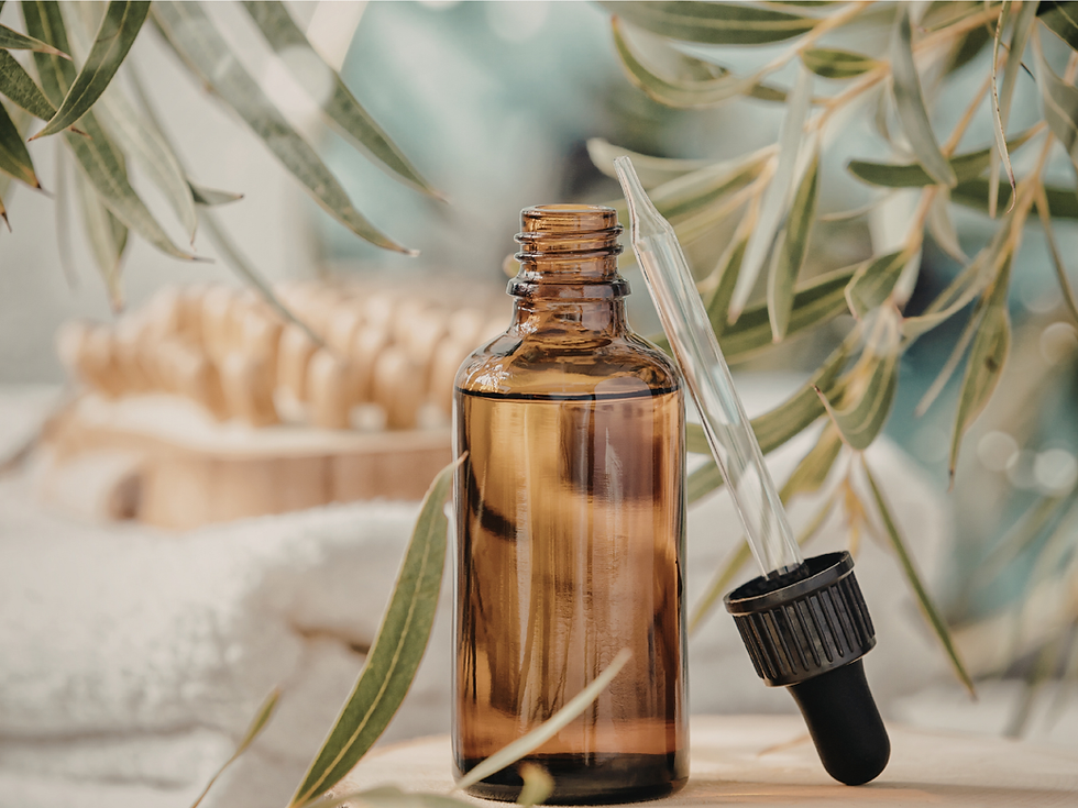 A glass bottle and dropper filled with an elixir surrounded by leaves.
