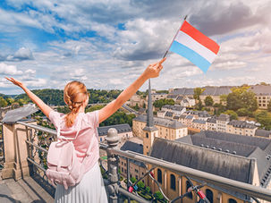 Dame regardant la ville de Luxembourg avec un drapeau en main
