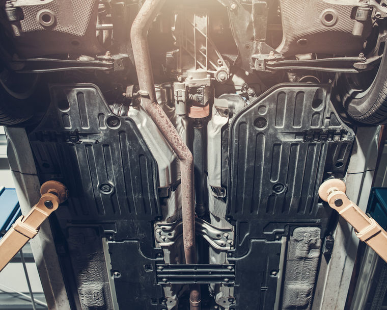 Chassis and underbody of a car raised on a lift ready for an MOT inspection
