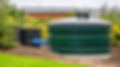 vecteezy_a-green-water-tank-sitting-in-the-middle-of-a-field_68448932.jpeg