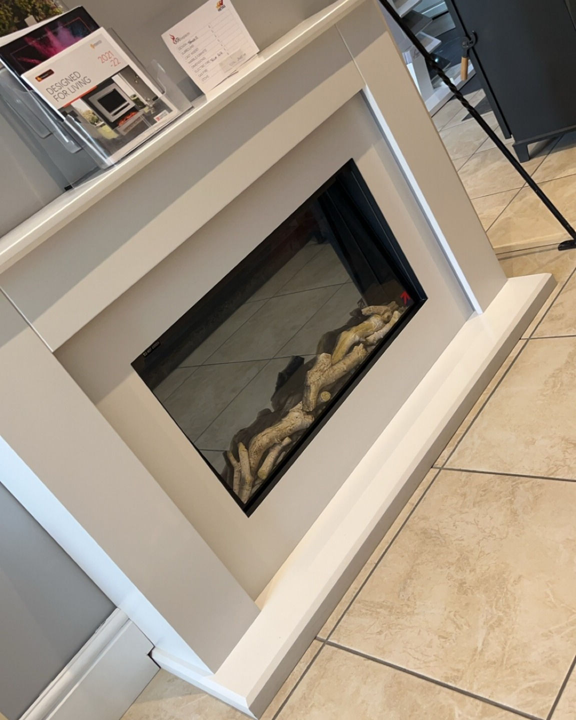 Wide inset fire in a white surround on display in the showroom