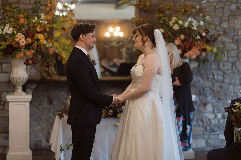 wedding couple say their vows against backdrop of autumn flowers