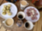 Wooden table with cups of coffee and plates with indigenous foods