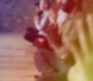 People meditating while sitting in room.