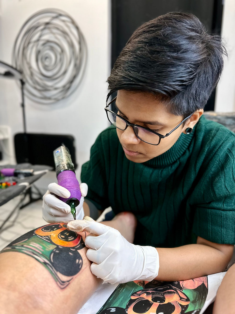 Roy, owner of Roy Tattoo Art, shading a color Mickey Mouse tattoo in Nova Scotia, Canada