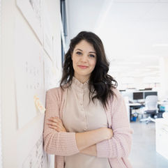 Professional portrait photography in Dubai: Headshot of a young woman in a modern white office.