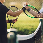 Two young man shaking hands after playing tennis. Tennis players shaking hands over the ne