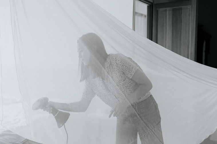 Photo du témoin de la mariée repassent le voile pendant les préparatifs au Domaine WE - Côte d'Opale