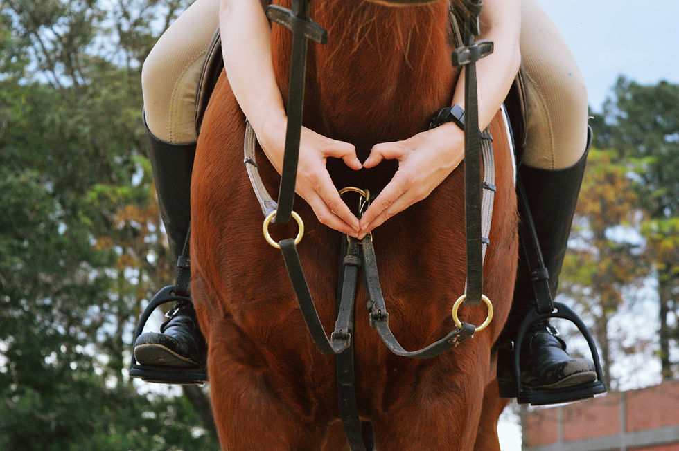 Someone making a heart sitting on a horse