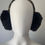 Thumbnail: Michael Kors Earmuffs front view on mannequin showing black plush ear pads and MK logo patterned headband