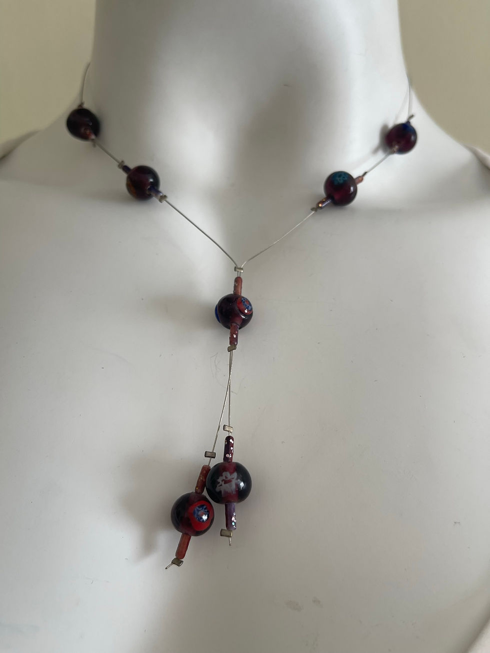 Beaded Wire Necklace – front view with dark round beads on fine wire and inner blue, green, yellow flower detail